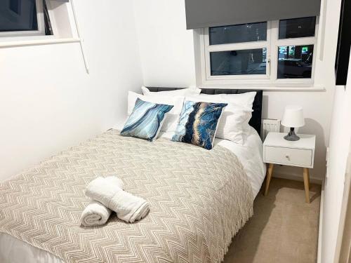 uma cama com uma toalha num quarto em Secure parking 3 bedroom stylish house with garden em Manchester