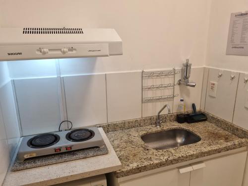 uma cozinha com um lavatório e um fogão em Flat 606 Golden Dolphin Express em Caldas Novas