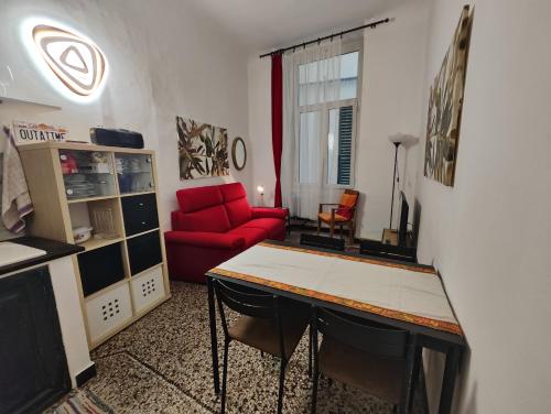 ein Wohnzimmer mit einem roten Sofa und einem Tisch in der Unterkunft Iron Home in Genua