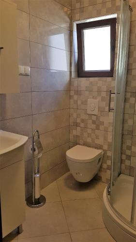 a bathroom with a toilet and a window at Apartments Jerko in Vrboska