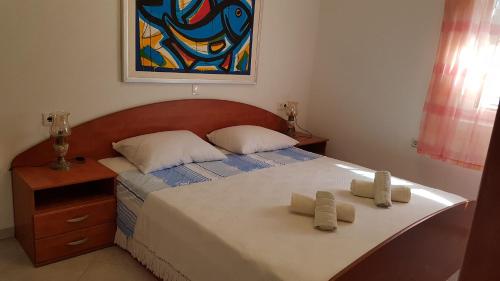 a bedroom with a bed with two towels on it at Apartments Jerko in Vrboska