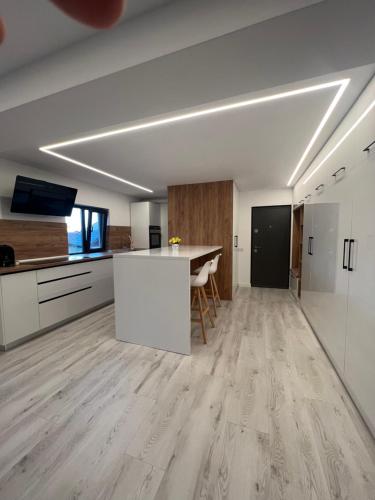 eine offene Küche und ein Wohnzimmer mit Holzboden in der Unterkunft MODERN PREMIUM APARTMENT 1 in Târgovişte