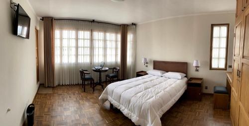 ein Schlafzimmer mit einem großen Bett und einem Tisch in der Unterkunft HOSPEDAJE SARABIA in Sucre