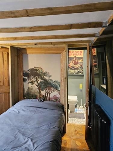 a bed in a room with a painting on the wall at Shoreditch Heights- Central ground floor apartment in Exeter