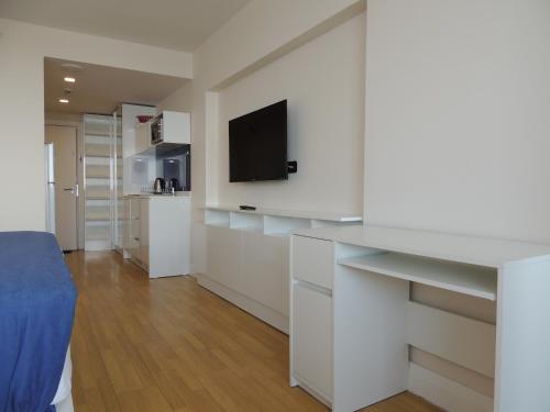 a living room with white cabinets and a flat screen tv at Orbi City Superhost in Batumi