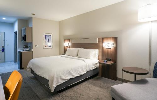 a hotel room with a large bed and a chair at Holiday Inn Express Hotel & Suites Cedar Hill, an IHG Hotel in Cedar Hill