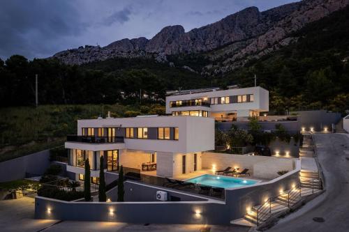a large white house with a swimming pool at night at Villa Ivan in Omiš