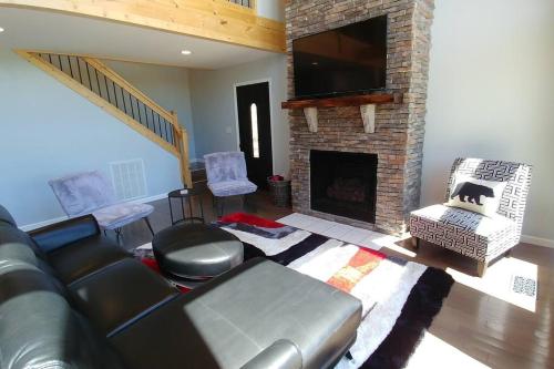 a living room with a couch and a fireplace at Peace of Heaven ~ Modern Chic Cabin w/ Majestic Mountain Views in Bryson City