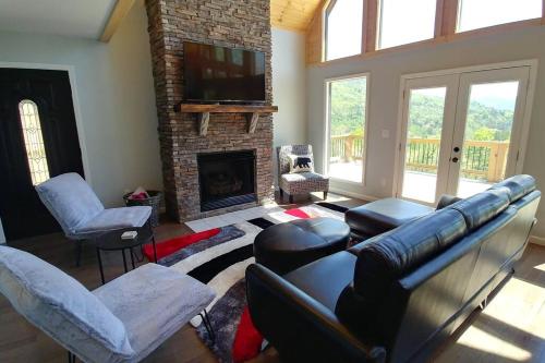 a living room with a couch and a fireplace at Peace of Heaven ~ Modern Chic Cabin w/ Majestic Mountain Views in Bryson City