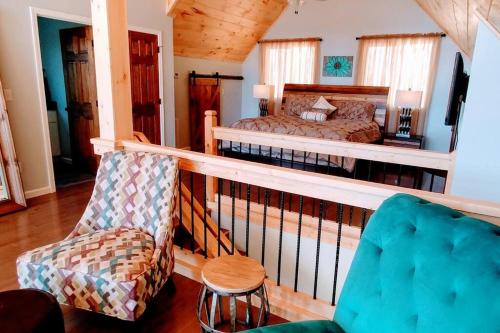 a bedroom with a bed and a chair at Peace of Heaven ~ Modern Chic Cabin w/ Majestic Mountain Views in Bryson City