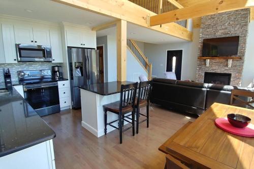 a kitchen and living room with a couch and a table at Peace of Heaven ~ Modern Chic Cabin w/ Majestic Mountain Views in Bryson City