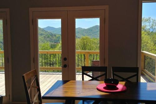 a dining room with a table and a view of the mountains at Peace of Heaven ~ Modern Chic Cabin w/ Majestic Mountain Views in Bryson City