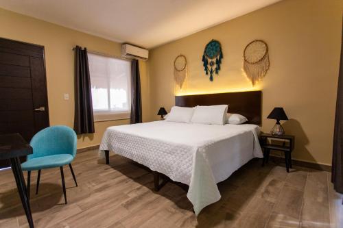 1 dormitorio con 1 cama y 1 silla azul en Ammare Hotel Boutique, en Playa del Carmen