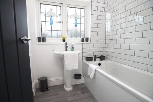 Un baño blanco con bañera y lavabo. en Sandringham House, en Redcar