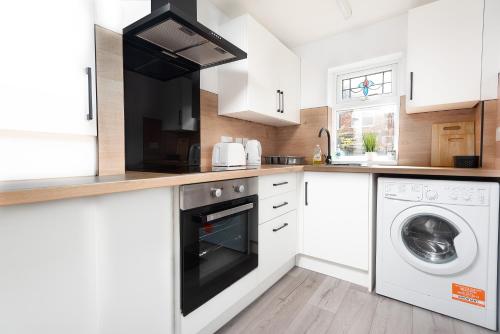 a white kitchen with a washer and dryer at Sandringham House in Redcar