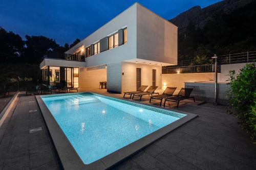 a house with a swimming pool in front of it at Villa Ivan in Omiš