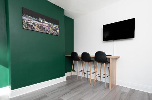 a room with green walls and a table with stools at Sandringham House in Redcar
