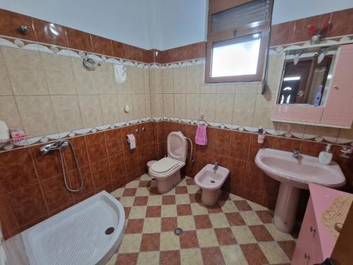 La salle de bains est pourvue de toilettes, d'un lavabo et d'une baignoire. dans l'établissement Vila Dhimo, 