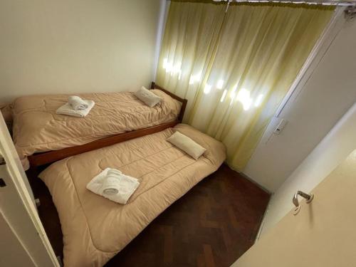 two beds in a small room with towels on them at Cómodo departamento céntrico in Mendoza