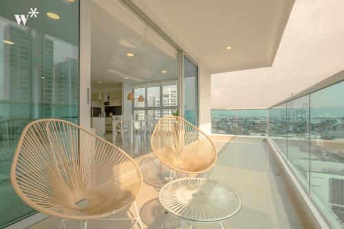 2 sillas y mesas en un balcón con ventanas en Wynwood Las Flores in Cartagena, en Cartagena de Indias