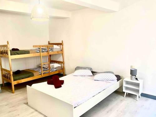 - une chambre avec 2 lits superposés et une croix rouge sur le lit dans l'établissement 2 T2 proche place Carnot BOX A BAGAGES GRATUITS, à Carcassonne