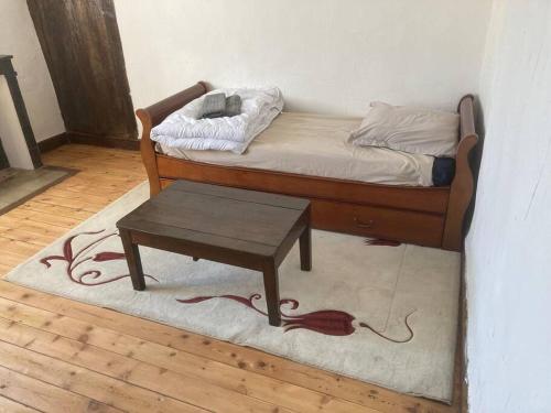 Habitación con cama con mesa sobre alfombra en Studio au château de Lachau, en Lachau