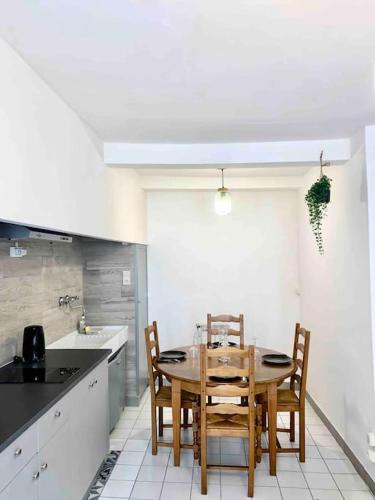 une cuisine avec une table et des chaises dans une pièce dans l'établissement 2 T2 proche place Carnot BOX A BAGAGES GRATUITS, à Carcassonne