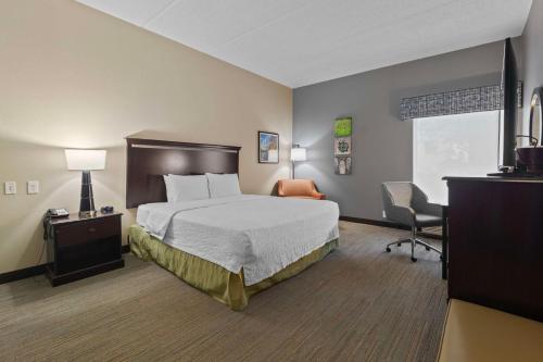 a bedroom with a bed and a desk and a chair at Hampton Inn Atlanta-Woodstock in Woodstock