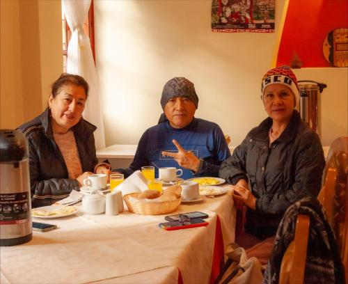 Un groupe de trois personnes assises à une table dans l'établissement Inka's Haven Hotel, à Ollantaytambo