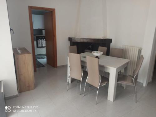 ein Esszimmer mit einem weißen Tisch und Stühlen in der Unterkunft House San cataldo in San Cataldo