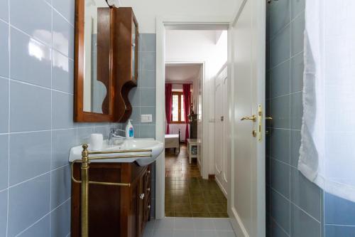 baño con lavabo, espejo y pasillo en Casaletto Del Pellegrino, en Viterbo