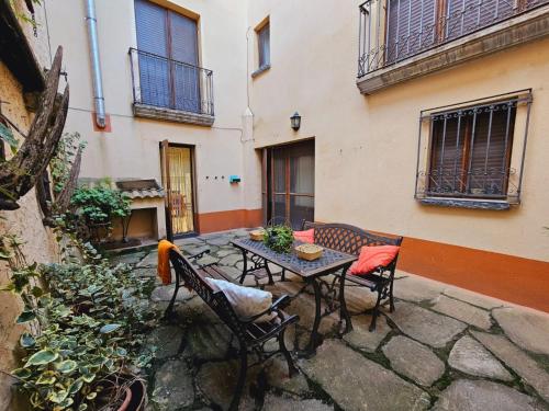 a patio with a table and chairs in front of a building at Lagar de Palacio in Santa Cilia de Jaca