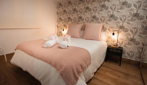 ein Schlafzimmer mit einem Bett mit zwei Hausschuhen darauf in der Unterkunft La Concha Pearl Beach Apartment in San Sebastián