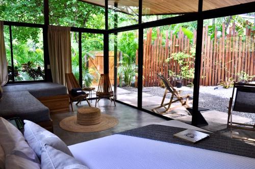 a living room with a bed and a view of a garden at Villas Kalei in Playa Grande