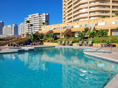 una gran piscina frente a un edificio en 2BD Beach Front Condo with Pool & More, en Rosarito