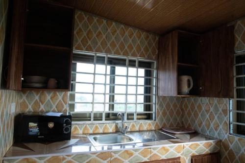 cocina con fregadero y ventana en Holly House, en Accra