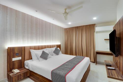 a bedroom with a bed and a flat screen tv at Collection O Manu in Bengaluru