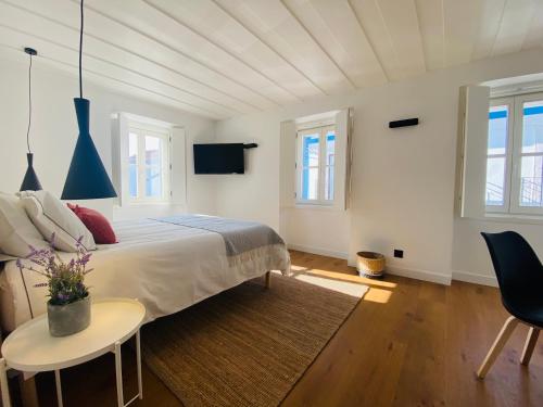 a bedroom with a bed and a table and chairs at Grândola Suites - Suite Afonso in Grândola