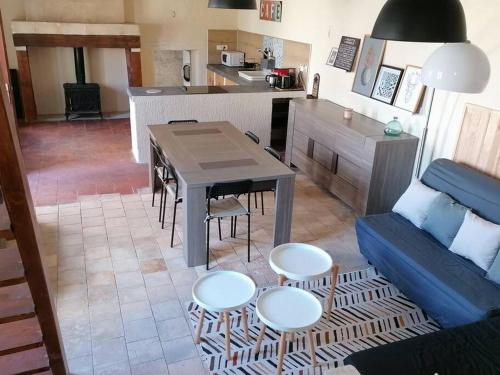 uma sala de estar com mesa e cadeiras e uma cozinha em Maison chaleureuse avec cheminée em Bourgueil