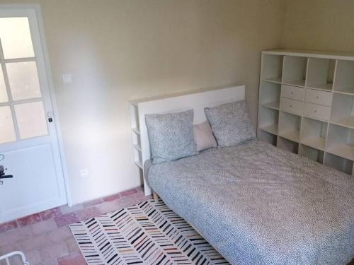um pequeno quarto com uma cama num quarto em Maison chaleureuse avec cheminée em Bourgueil