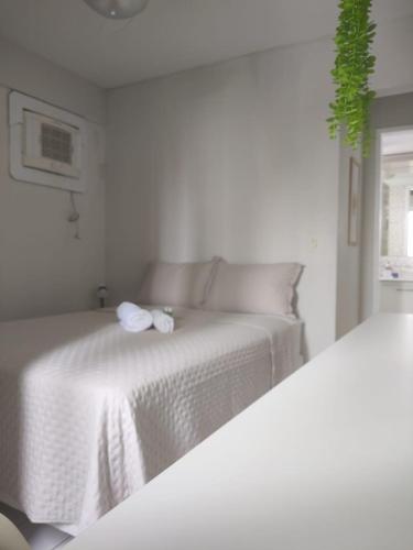 a white bedroom with a bed with a flower on it at Apartamento de 2 quartos in Recife