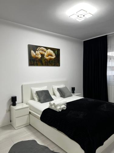 - une chambre dotée d'un lit avec des draps noirs et blancs dans l'établissement New Residence Apartament, à Popeşti-Leordeni