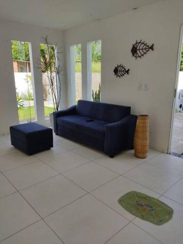 a living room with a blue couch and a rug at Casa de Praia em Condomínio Fechado em Alagoas! in Paripueira