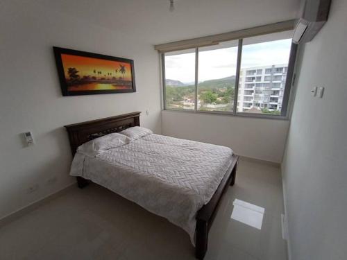 ein kleines Schlafzimmer mit einem Bett und einem Fenster in der Unterkunft Apartamento en Ricaurte Cundinamarca in Ricaurte