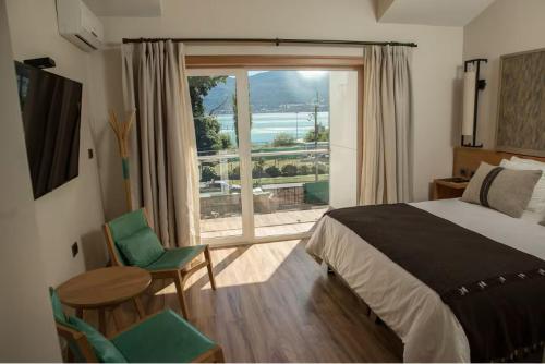 um quarto com uma cama, uma mesa e uma janela em Hotel casa Solaria em Pucón