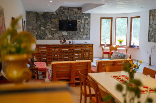 a dining room with tables and chairs and a tv at LerMont Guest House in Lermontovo