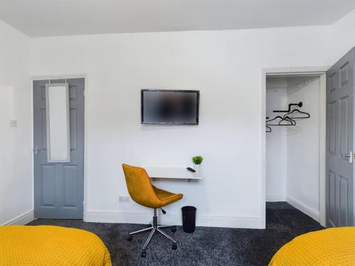 um quarto com 2 camas, uma secretária e uma cadeira em Cliff House By RMR Accommodations - NEW - Sleeps 8 - Modern - Parking em Stoke on Trent