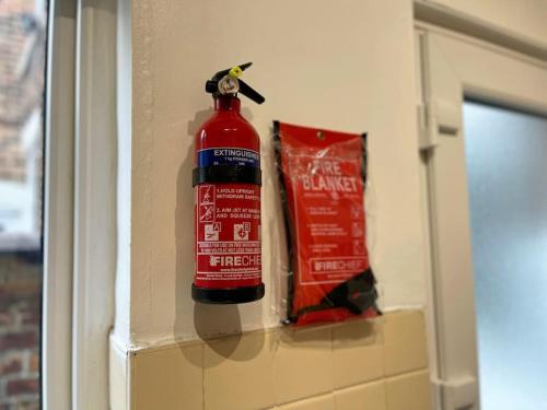a fire extinguisher is hanging on the wall at Cliff House By RMR Accommodations - NEW - Sleeps 8 - Modern - Parking in Stoke on Trent