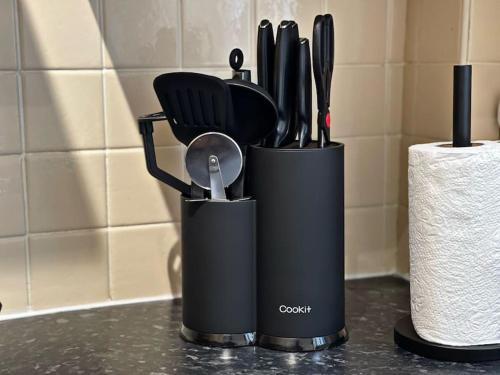 a black container with utensils on a counter at Cliff House By RMR Accommodations - NEW - Sleeps 8 - Modern - Parking in Stoke on Trent
