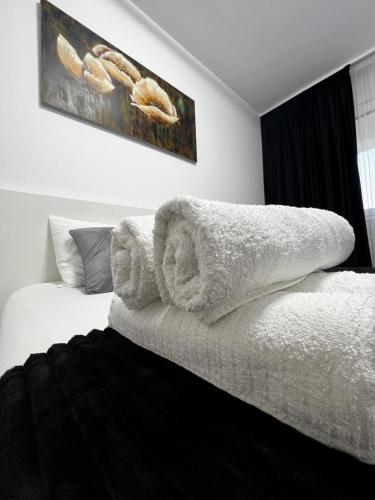 - une chambre avec des serviettes blanches sur un lit dans l'établissement New Residence Apartament, à Popeşti-Leordeni